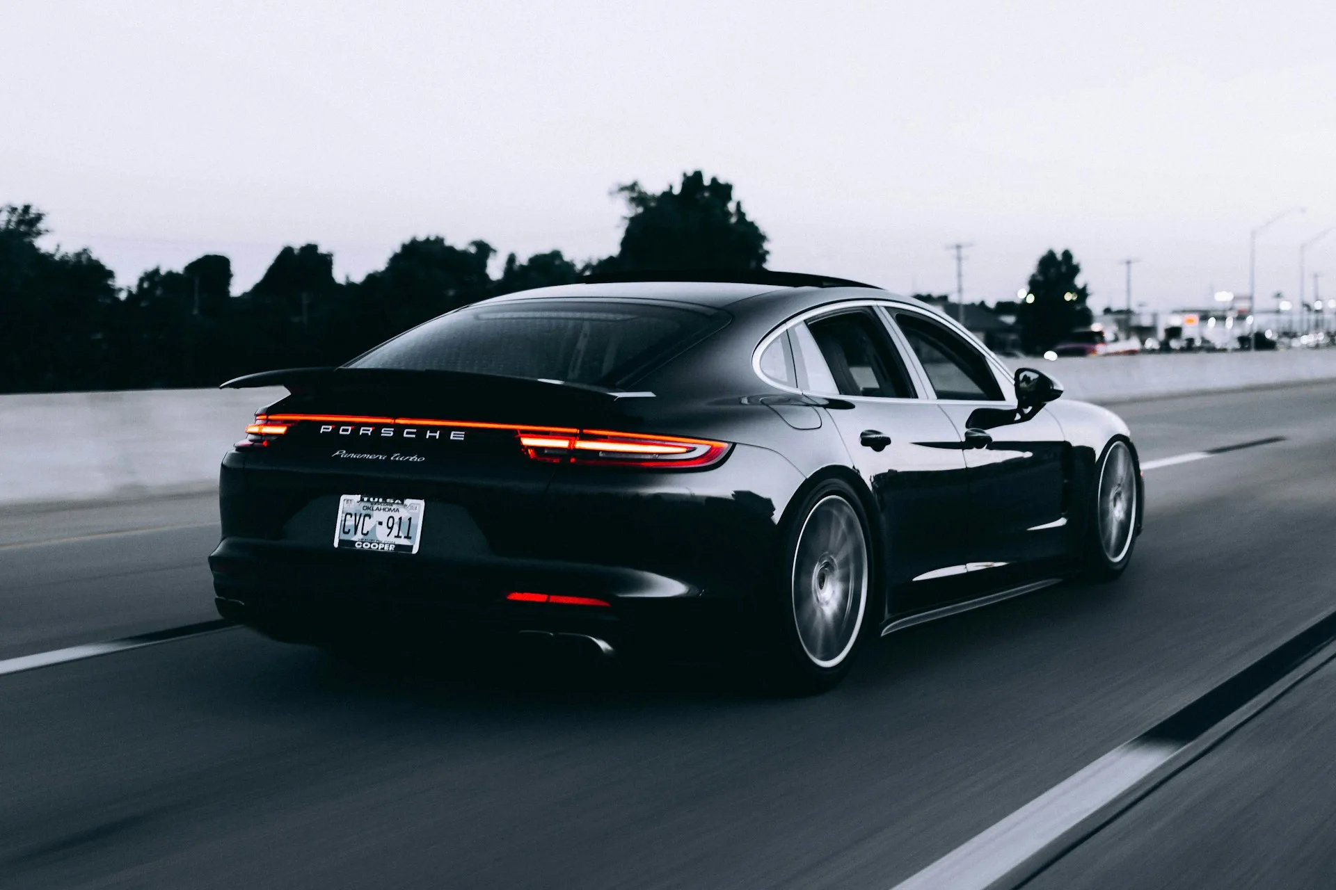 Porsche preto em movimento em uma estrada