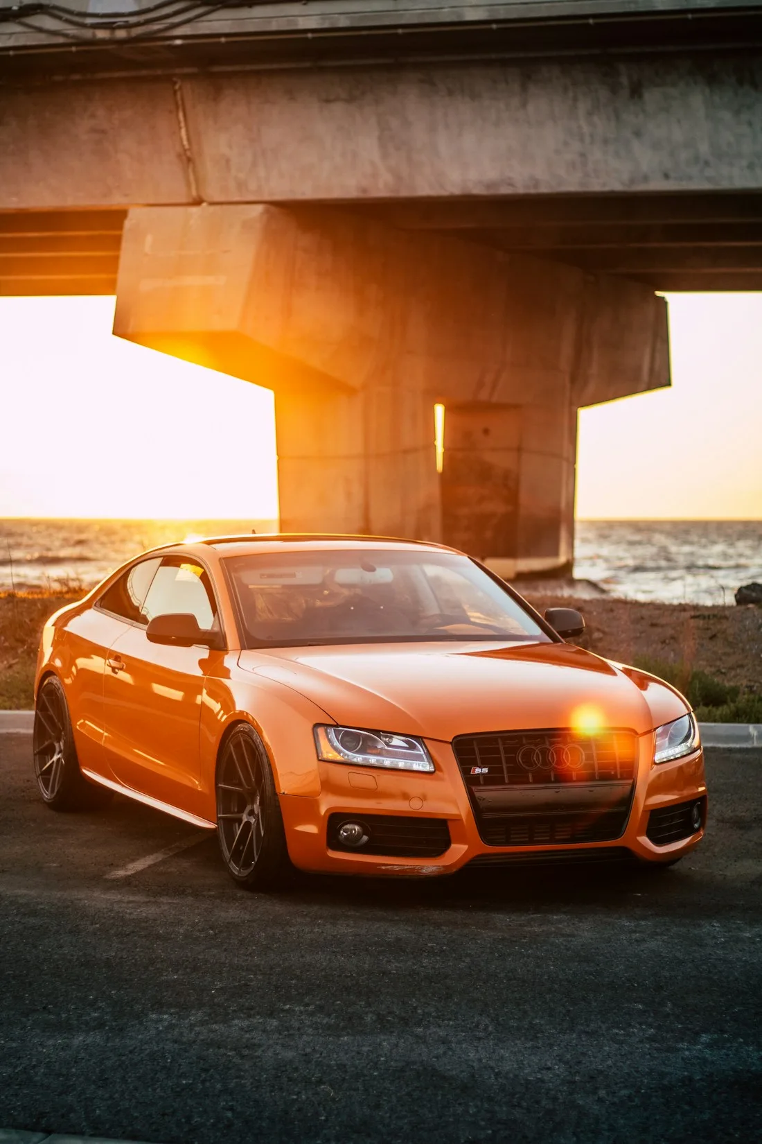 Cupê Audi vermelho fotografado ao pôr do sol