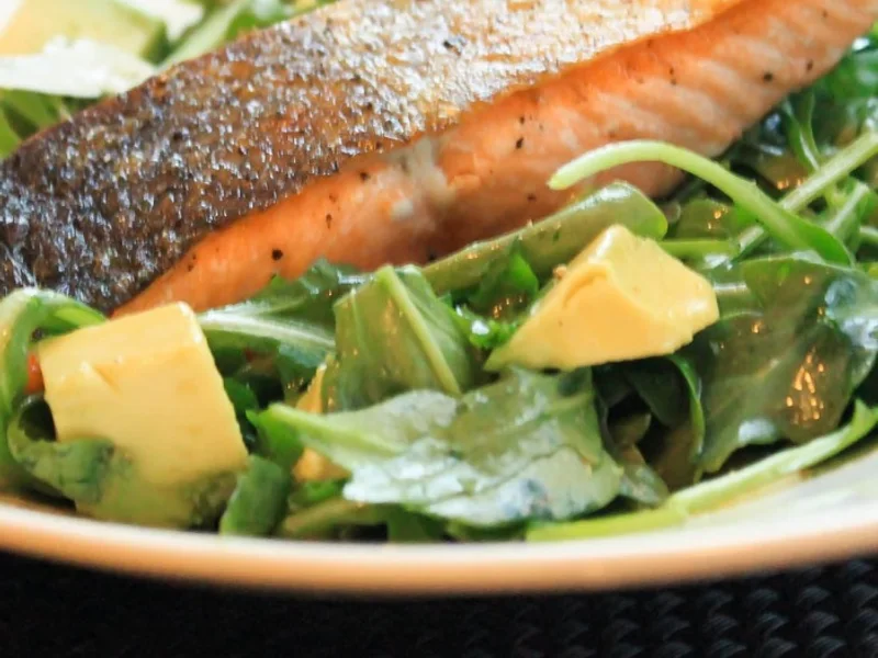 Salmão, abacate e folhas frescas em uma composição leve com toque de limão.